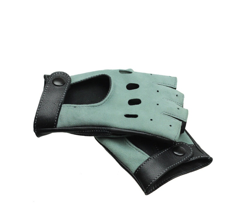 May include: A pair of fingerless gloves made of light blue suede with black leather trim and a button closure.