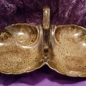 May include: A brown ceramic serving dish with a handle. The dish has three sections and a speckled glaze.