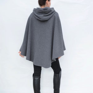 May include: A gray hooded cape with a long, flowing design. The cape is made of a soft, comfortable fabric and has a relaxed fit.