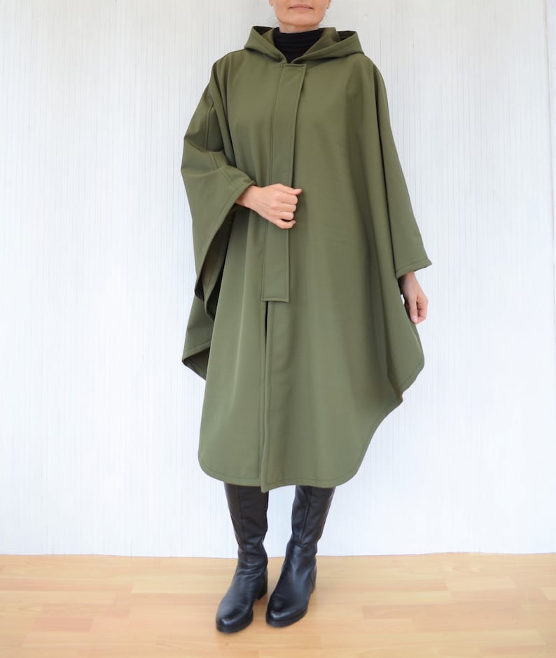 May include: A long, hooded, green cape with a tie closure. The cape is made of a soft, lightweight fabric and has a relaxed fit.
