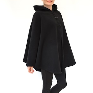 Puede incluir: Una capa negra con capucha y un dise&ntilde;o largo y fluido. La capa tiene un estilo simple y elegante y est&aacute; hecha de una tela suave y c&oacute;moda.