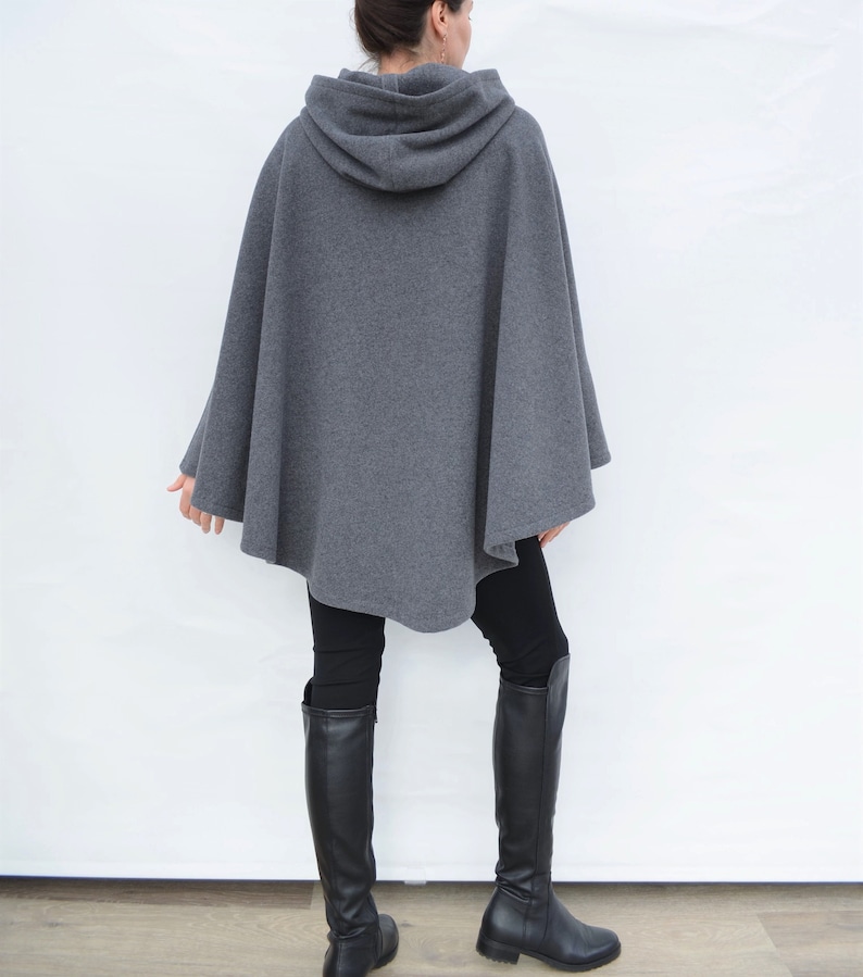 May include: A gray hooded cape with a long, flowing design. The cape is made of a soft, comfortable fabric and has a relaxed fit.