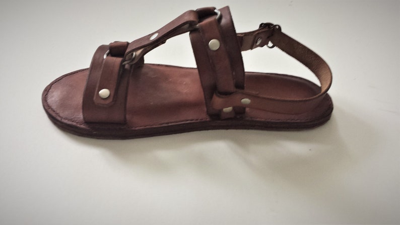 These sandals are made from Cowhide veg tan leather straps that goes around arch and heel with buckles on the side. Has an insole glued inside and hand stitched with wax string. Sandals are not orthotics.