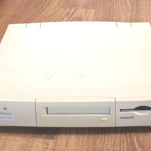 May include: A beige Macintosh Performa 6400 desktop computer featuring a front-loading optical disc drive, a floppy disk drive, and the PowerPC logo. The front panel displays the Apple logo and the text Macintosh Performa 6400.