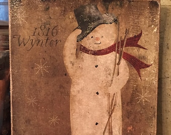 May include: A rustic wooden sign with a painted snowman wearing a black top hat and a red scarf. The sign has the text "1816 Wynter" and snowflakes in the background.