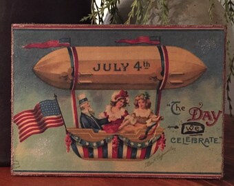 May include: Vintage patriotic artwork featuring a yellow airship with the text "JULY 4th". The airship carries Uncle Sam and two children. An American flag waves in the foreground. The text "The Day we CELEBRATE" is also present.