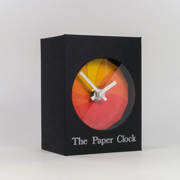 Black Paper Clock modern design gift item with accurate quartz movement, and red/orange colored face.