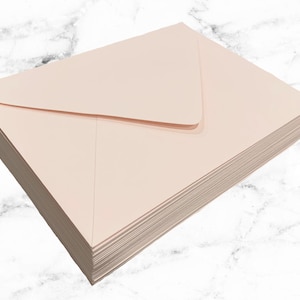 May include: A stack of pale pink envelopes, likely for sending invitations or correspondence.