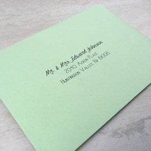 May include: A light green envelope with a black handwritten address that reads "Mr. & Mrs. Edward Johnson, 2040 Acorn Place, Huntingdon Valley, NY 19006"