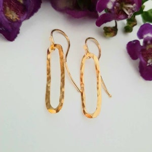 May include: A pair of gold-toned hammered oval earrings with a simple hook fastening.