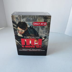 May include: A boxed set of the Mission: Impossible 4-Movie collection featuring Tom Cruise. The box has a clear plastic wrap and includes the movies Mission: Impossible, Mission: Impossible 2, Mission: Impossible 3, and Mission: Impossible Ghost Protocol.
