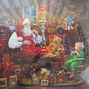 May include: A Christmas-themed image depicts Santa Claus in a red suit and hat, seated in a wooden rocking chair. A child in green pajamas sits nearby. A teddy bear, cookies, and Christmas stockings are also visible.