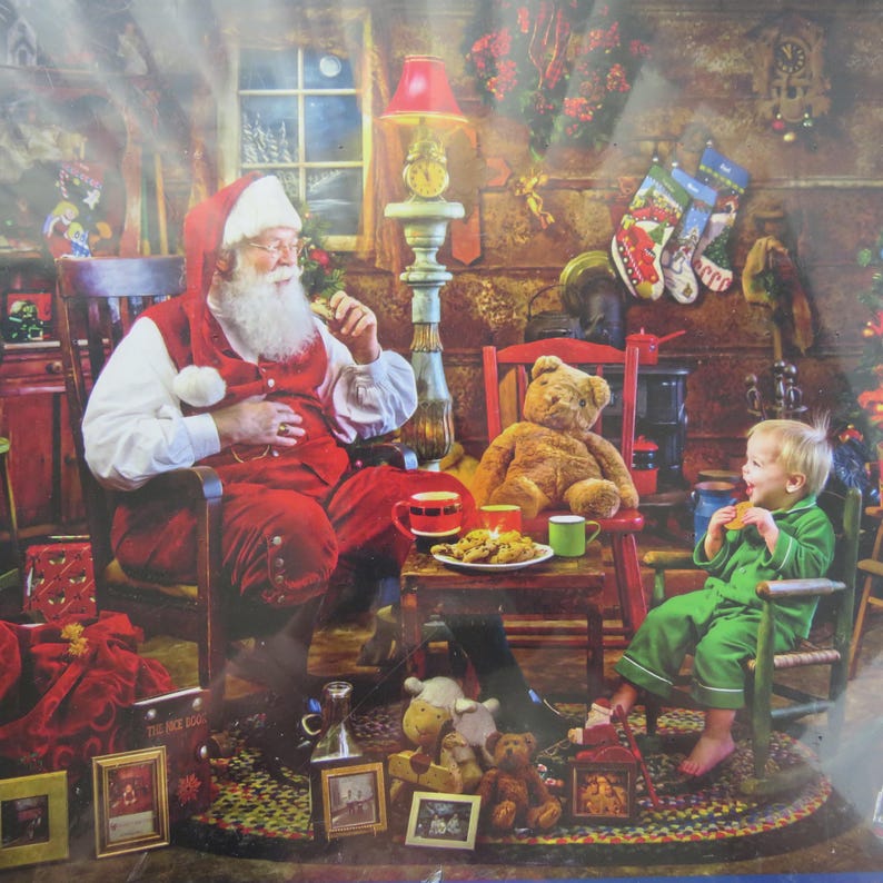 May include: A Christmas-themed image depicts Santa Claus in a red suit and hat, seated in a wooden rocking chair. A child in green pajamas sits nearby. A teddy bear, cookies, and Christmas stockings are also visible.