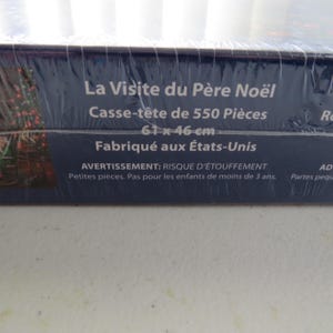 May include: A boxed jigsaw puzzle with the title "La Visite du P&egrave;re No&euml;l" (The Visit of Santa Claus). The puzzle contains 550 pieces and measures 24 x 18 inches. Made in the USA. Warning: choking hazard.