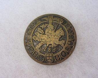 Medium vintage sewing button - jousting - knight on horse with a shield border
