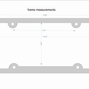 May include: A gray metal license plate frame with rounded corners and four holes. The frame measures 12.00 inches wide, 6.00 inches tall, 10.75 inches long, and 7.01 inches high.