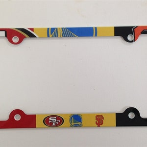 May include: A red, yellow, blue, and black license plate frame with the logos of the San Francisco 49ers, Golden State Warriors, and San Francisco Giants.