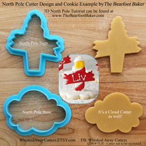 May include: A set of four cookie cutters for making a North Pole themed cookie. The cutters are blue and include a sign, a base, a snowman, and a cloud. The sign says "North Pole Sign" and the base says "North Pole Base".
