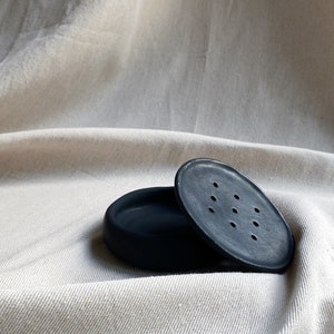 May include: A black ceramic soap dish with a lid. The lid has small holes for drainage.
