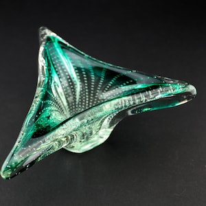 Peut inclure: Un bol en verre vert avec une surface texturée et une forme triangulaire.