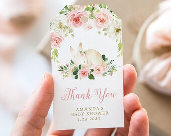Könnte beinhalten: Ein weißes Dankeschön-Etikett mit rosa und grünen Blumendesigns. Ein weißes Kaninchen schläft auf einem Bett aus rosa Rosen. Der Text auf dem Etikett lautet "Danke Amanda's Baby Shower 4.23.2023".