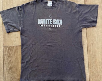 May include: A gray t-shirt with the words "White Sox Baseball" printed in white on the front. The shirt has a faded look and is made of a soft, comfortable material.