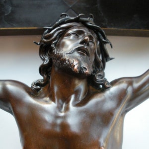 May include: A bronze sculpture of a man with a crown of thorns, depicting the crucifixion of Jesus Christ.
