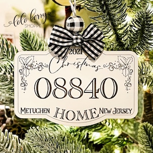 May include: White Christmas ornament with a black and white checkered bow, the text "2021 Christmas", the number "08840", and the words "Metuchen Home New Jersey".