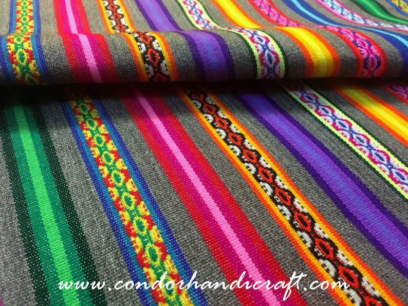 May include: Colorful striped fabric with a repeating pattern of geometric shapes. The fabric is woven with a variety of colors, including red, orange, yellow, green, blue, purple, and white. The fabric is folded in half, and the website address "www.condorhandicraft.com" is visible in the lower right corner.