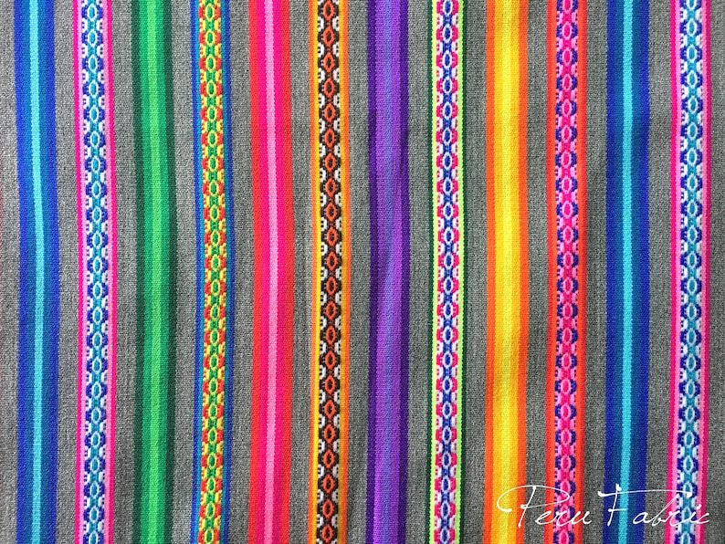 May include: Colorful striped fabric with a repeating pattern of geometric shapes. The fabric is woven with a variety of colors, including blue, green, red, orange, yellow, and purple. The fabric is made in Peru.