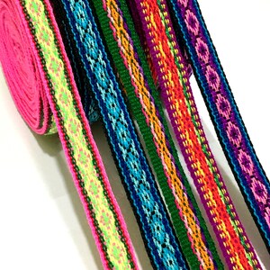 May include: Assortment of colorful woven ribbon trim with geometric patterns in pink, green, blue, purple, orange, and yellow.