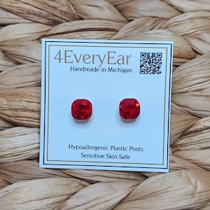 May include: A pair of square-cut red stud earrings mounted on a white display card. The card features the text 4EveryEar, Handmade in Michigan, Hypoallergenic Plastic Posts, and Sensitive Skin Safe, along with a QR code in the top right corner.
