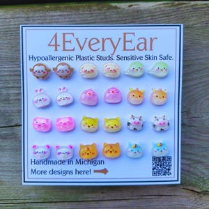 May include: A display of colorful hypoallergenic plastic stud earrings. The card reads "4EveryEar" and "Handmade in Michigan." The earrings feature various animal designs, including monkeys, bunnies, pigs, cats, cows, and more. The text "Hypoallergenic Plastic Studs. Sensitive Skin Safe." is also visible.