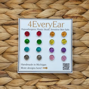 May include: A display card featuring 12 pairs of colorful stud earrings. The earrings are arranged in three rows of four, with a variety of colors including red, orange, green, yellow, blue, purple, and pink. The card reads "4EveryEar" and "Hypoallergenic Plastic Studs. Sensitive Skin Safe."