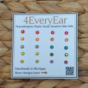 May include: A white card with the text "4EveryEar" and "Hypoallergenic Plastic Studs. Sensitive Skin Safe." features a grid of colorful, iridescent stud earrings. The card reads "Handmade in Michigan" and includes a QR code.