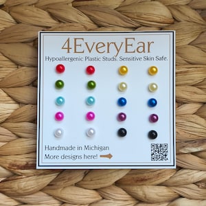May include: A set of twenty colorful stud earrings arranged in five rows on a white display card labeled 4EveryEar. The card features text stating Hypoallergenic Plastic Studs. Sensitive Skin Safe. and Handmade in Michigan with a QR code.
