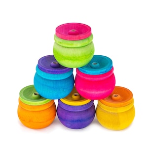 May include: A set of six colorful wooden stacking rings. The rings are arranged in a pyramid shape, with the largest ring at the bottom and the smallest ring at the top. The rings are painted in a variety of bright colors, including red, orange, yellow, green, blue, and purple.