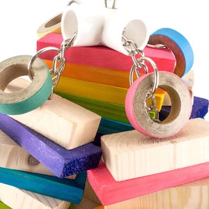 May include: A colorful wooden bird toy with multiple rings and a white plastic connector. The toy is made of natural wood and is safe for birds.
