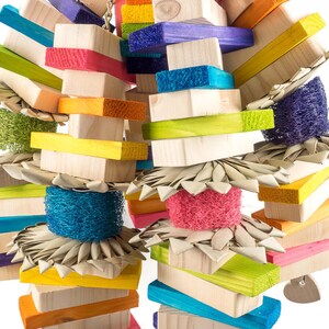 May include: A colorful wooden bird toy with multiple layers of wood blocks, woven straw, and colorful sponges. The toy is designed for birds to chew and play with.