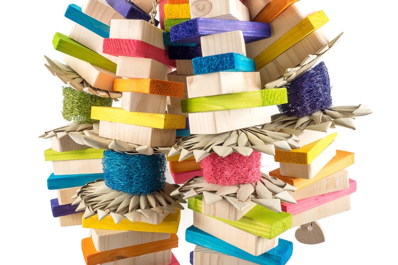 May include: A colorful wooden bird toy with multiple layers of wood blocks, woven straw, and colorful sponges. The toy is designed for birds to chew and play with.