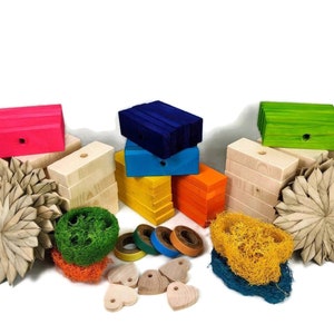 May include: A set of colorful wooden blocks, natural wood blocks, and natural woven toys for small pets. The set includes a variety of shapes and sizes, including hearts, stars, and circles. The blocks are painted in bright colors, including pink, blue, green, yellow, and orange.