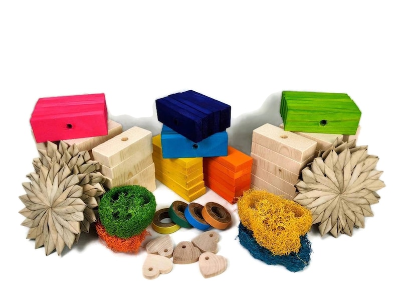 May include: A set of colorful wooden blocks, natural wood blocks, and natural woven toys for small pets. The set includes a variety of shapes and sizes, including hearts, stars, and circles. The blocks are painted in bright colors, including pink, blue, green, yellow, and orange.