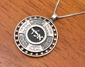 May include: A silver necklace with a round pendant featuring a black onyx center with Hebrew lettering. The pendant is surrounded by a circle of Hebrew text and stars.