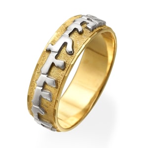 May include: A gold wedding band with a textured surface and Hebrew lettering in white gold.