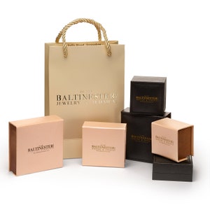Puede incluir: Un conjunto de seis cajas con el texto "BALTINESTER: JEWELRY & JUDAICA" impreso en ellas. Las cajas son de varios tama&ntilde;os y est&aacute;n hechas de cart&oacute;n marr&oacute;n. Las cajas est&aacute;n dispuestas en forma de pir&aacute;mide. Las cajas est&aacute;n sobre una superficie blanca. Hay una bolsa de compras beige con el texto "BALTINESTER: JEWELRY & JUDAICA" impreso en ella.