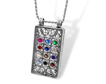 May include: A silver necklace with a rectangular pendant featuring a filigree design and twelve colorful gemstones.