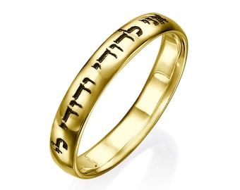 May include: A gold band ring with Hebrew text inscribed around the band.