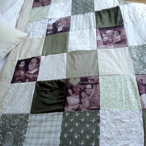 May include: A patchwork quilt with a white background and green and brown squares. Each square features a different black and white photograph of people. The quilt is made of different fabrics, including paisley and plaid.
