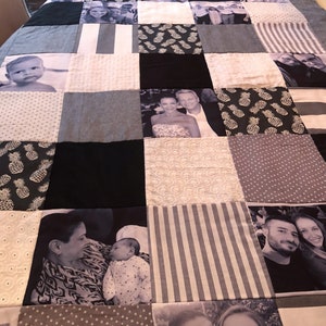 May include: A black and white photo quilt featuring various images of people and patterns. The quilt is made up of squares with different designs, including pineapples, polka dots, stripes, and floral patterns. The quilt is a great way to display family photos and memories.