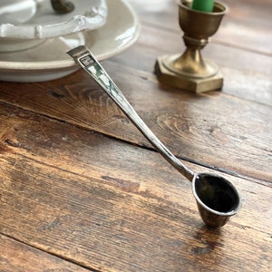 Może przedstawiać: Srebrna chochla z długim uchwytem i zaokrągloną miską. Chochla ma mały napis na uchwycie, który brzmi "H.C. Co."